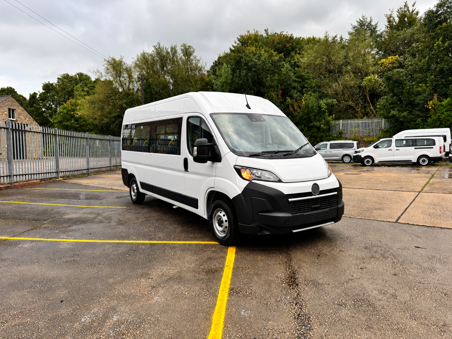 White Minibus in a Wet Parking Lot